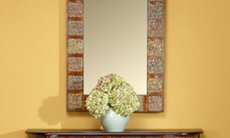 A yellow wall with flowers and a mirror