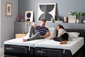 Couple laying on a Tempur-Pedic adjustable mattress