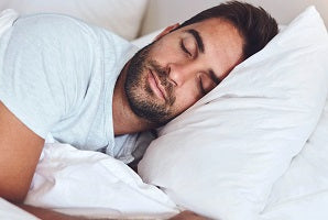 man sleeping on his side with a pillow