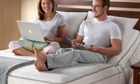 A couple sitting up on an adjustable bed