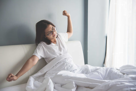 Woman stretching out in bed