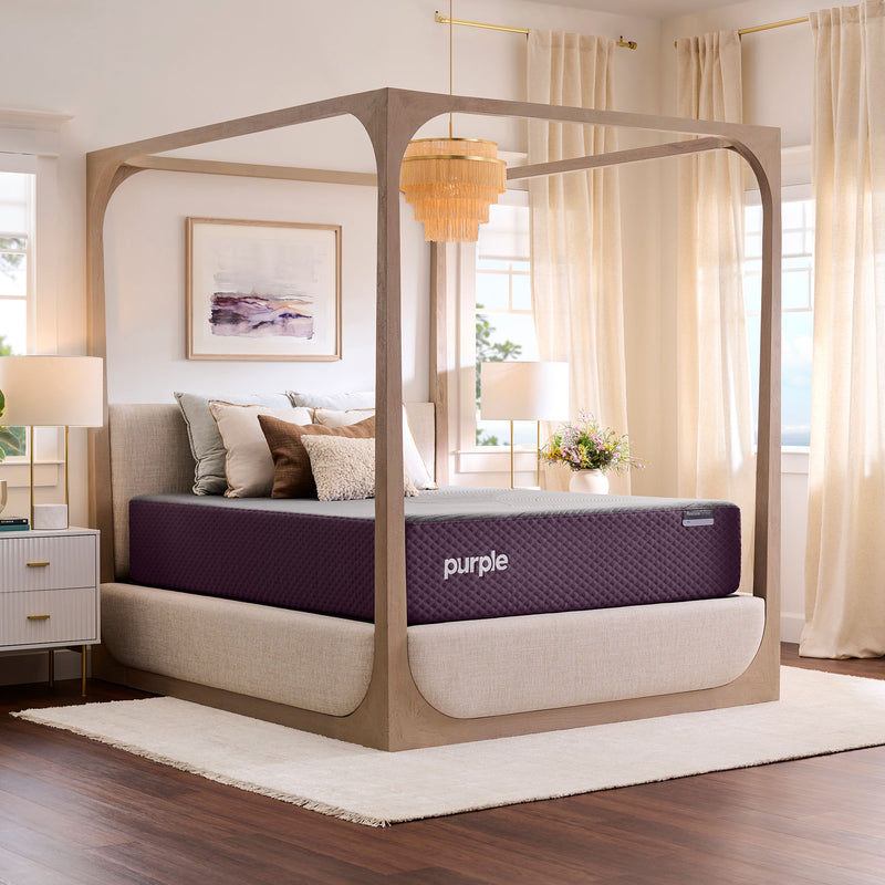 Purple mattress on canopy bed in bedroom