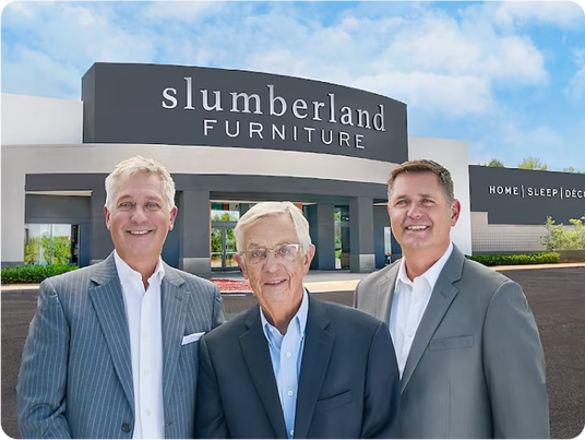 Slumberland founders in front of store